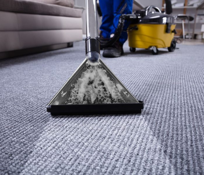 Janitor's Hand Cleaning Carpet With Vacuum Cleaner