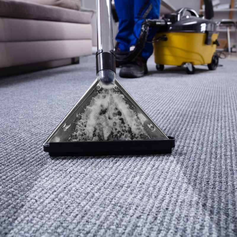 Janitor's Hand Cleaning Carpet With Vacuum Cleaner